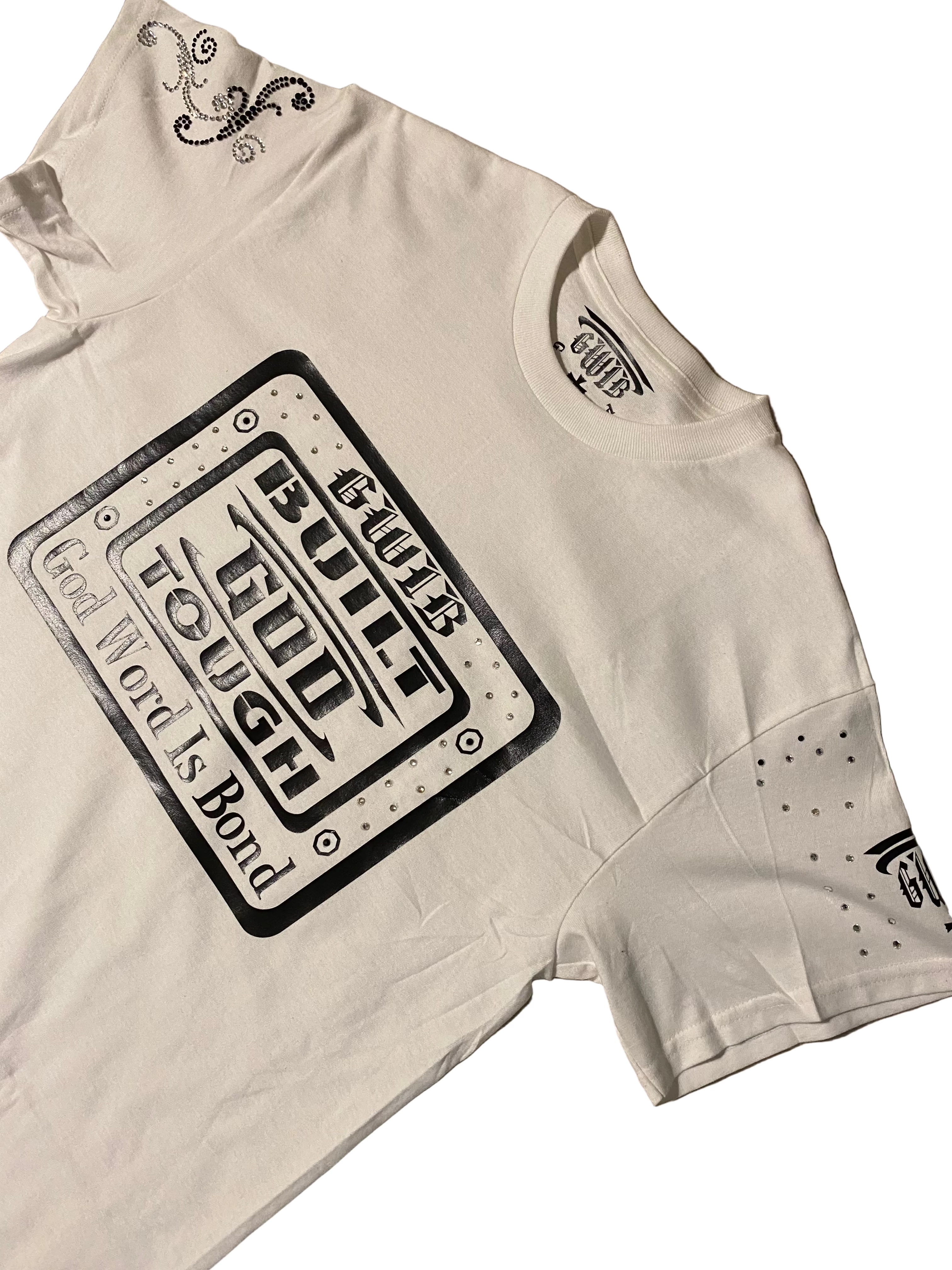 White T shirt with black lettering Built God Tough with rhinestones.